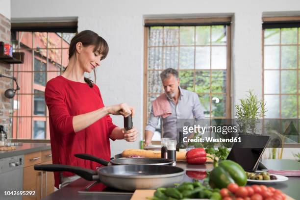 couple in kitchen, preparing food toghether - middle aged couple cooking stock-fotos und bilder