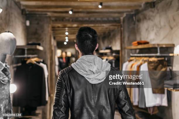 rear view of man in modern menswear shop - entering shop stock pictures, royalty-free photos & images