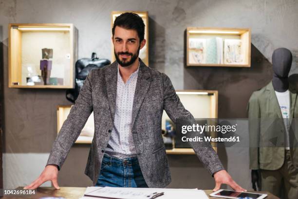 portrait of confident man in menswear shop - estilista de moda designer profissional imagens e fotografias de stock