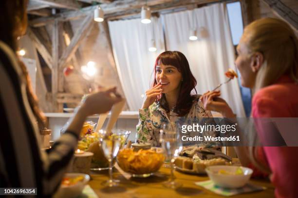 happy female friends having dinner at home together - freundinnen wein stock-fotos und bilder