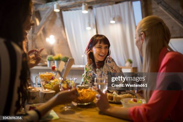 happy female friends having dinner at home together - cena fotografías e imágenes de stock
