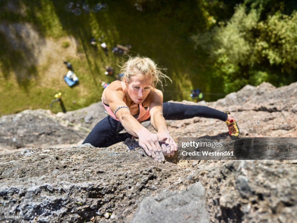 Austria, Innsbruck, Hoettingen quarry, woman climbing in rock wall