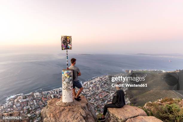 south africa, cape town, lions head, sea point, couple enjoying the view at sunset - sea point cape town stock pictures, royalty-free photos & images