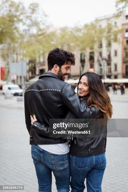 spain, barcelona, young couple embracing and walking in the city - barcelona fashion day 2 stockfoto's en -beelden