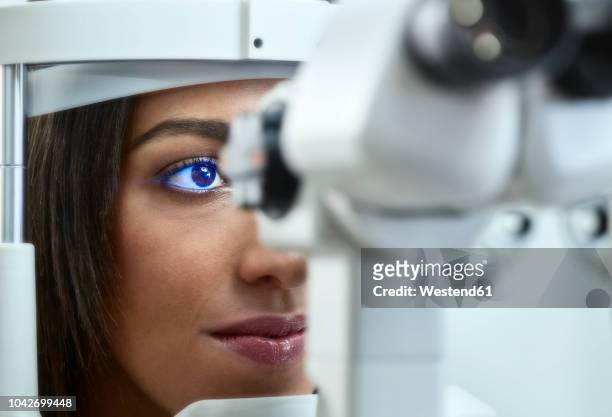 optician, young woman during eye test - optometria foto e immagini stock