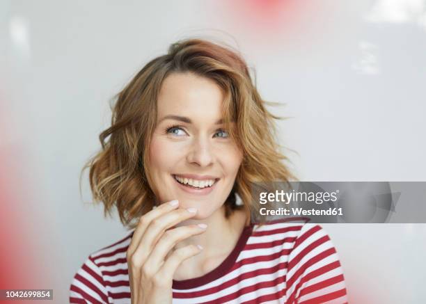 portrait of smiling woman wearing red-white striped t-shirt - einzelne frau über 30 stock-fotos und bilder