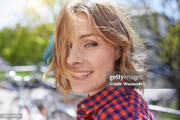 portrait of smiling woman outdoors - plaid shirt stock-fotos und bilder