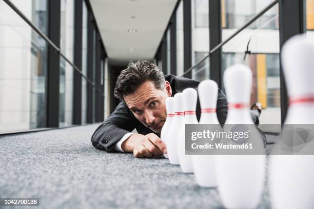 diligent manager lying on the floor in office passageway adjusting pins - adjusting bildbanksfoton och bilder