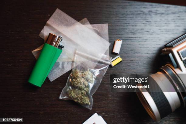 marihuana, cigarette lighter and analog camera on wood - sachet stockfoto's en -beelden