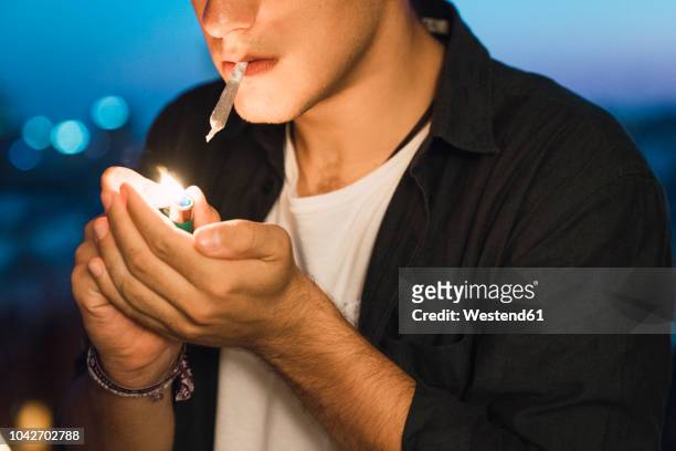 young man smoking a joint - joint body part stock-fotos und bilder