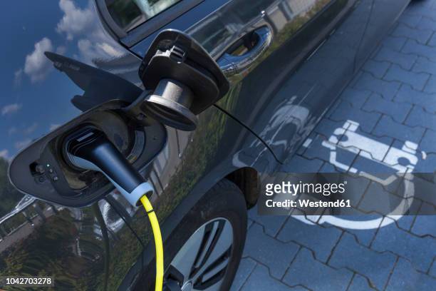 charging of an electric car - electronic car stock-fotos und bilder