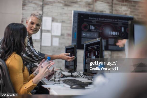 adult education, instructor talking to student at computer training centre - praticando imagens e fotografias de stock