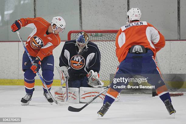 Rick DiPietro of the New York Islanders makes the save against Josh Bailey and Frans Nielsen during a training camp session at Iceworks on September...