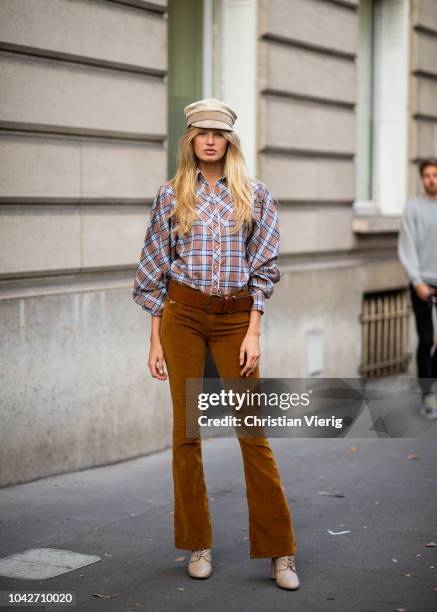 Dutch model Romee Strijd wearing flat cap, checked button shirt, brown flared pants, boots is seen during Paris Fashion Week Womenswear Spring/Summer...