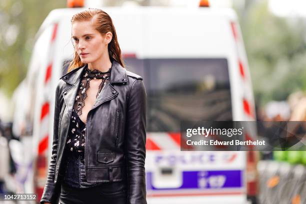 Model Alexina Graham wears a black leather jacket, a black lace mesh top, a bag, outside Balmain, during Paris Fashion Week Womenswear Spring/Summer...