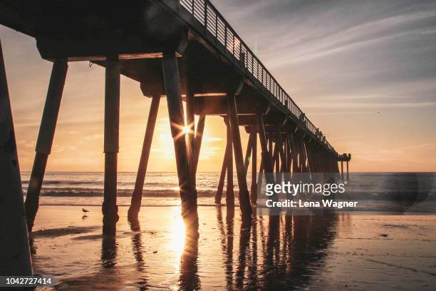 sunshine through the pier - playa hermosa en california fotografías e imágenes de stock