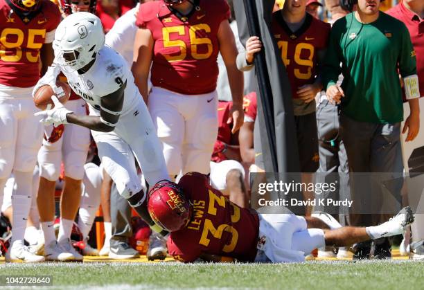 Wide receiver Jonah Morris of the Akron Zips is tackled by defensive back Braxton Lewis of the Iowa State Cyclones as he rushed for yards in the...