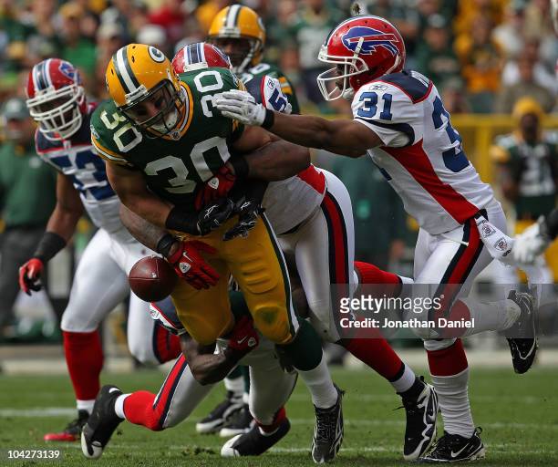 John Kuhn of the Green Bay Packers fumbles the ball as he is hit by members of the Buffalo Bills defense including Jarius Byrd at Lambeau Field on...