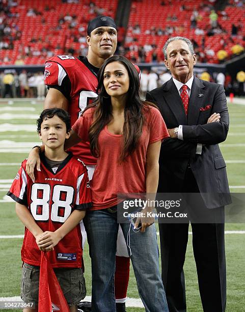 Tony Gonzalez of the Atlanta Falcons poses with his wife October, son Nikko and Owner and CEO Arthur Blank after receiving an award for his 1000th...