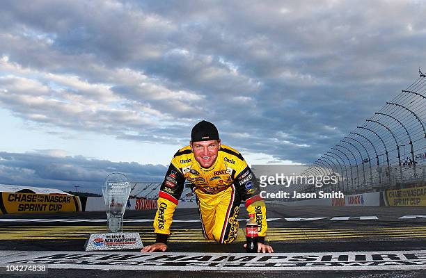 Clint Bowyer, driver of the Cheerios / Hamburger Helper Chevrolet, poses at the start/finish line after he won the NASCAR Sprint Cup Series Sylvania...