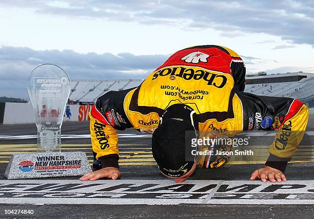 Clint Bowyer, driver of the Cheerios / Hamburger Helper Chevrolet, kisses the start/finish line after he won the NASCAR Sprint Cup Series Sylvania...