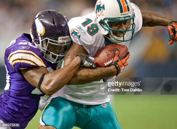 Brandon Marshall of the Miami Dolphins is tackled by Madieu Williams of the Minnesota Vikings during an NFL game at Mall of America Field at the...