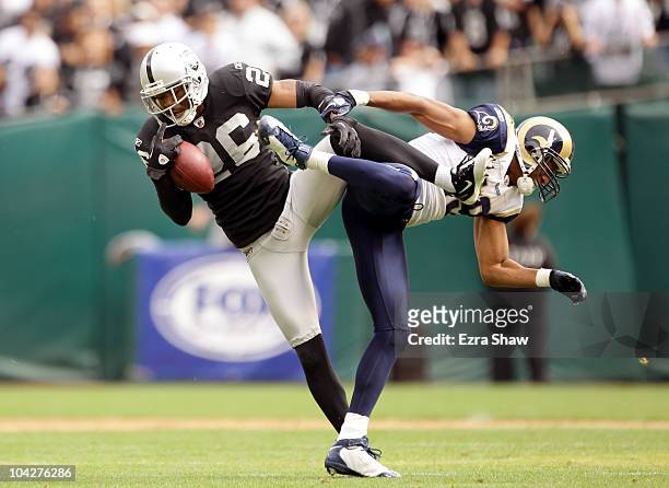 Stanford Routt of the Oakland Raiders intercepts a pass intended for Laurent Robinson of the St. Louis Rams at the Oakland-Alameda County Coliseum on...