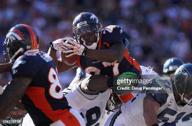 Running back Knowshon Moreno of the Denver Broncos goes over defensive tackle Colin Cole of the Seattle Seahawks for a one yard touchdown in the...