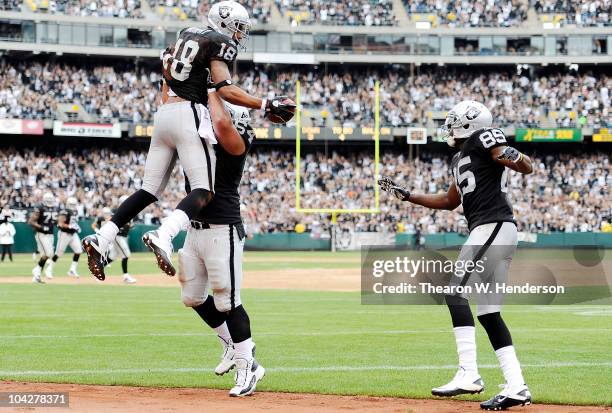 Wide Receiver Louis Murphy of the Oakland Raiders after catching a touchdown pass against the St. Louis Rams is lifted in the air by center Samson...