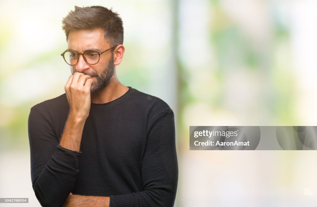 Erwachsenen hispanic Mann mit Brille über isolierte Hintergrund suchen Sie gestresst und nervös die Hände auf Mund beißen Nägel. Angst-Problem.