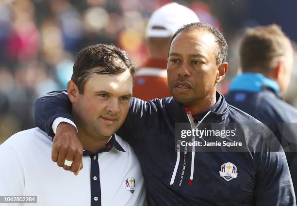 Tiger Woods of the United States consolls Patrick Reed of the United States following defeat during the morning fourball matches of the 2018 Ryder...