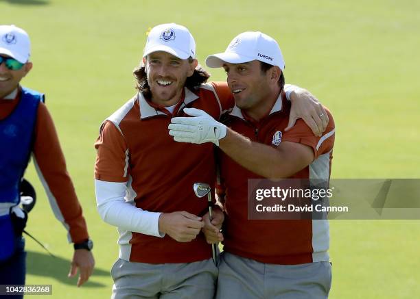 Tommy Fleetwood of England and the European Team embraces his partner Francesco Molinari after Molinari had hit a great shot to the 15th green which...