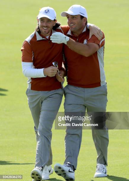 Tommy Fleetwood of England and the European Team embraces his partner Francesco Molinari after Molinari had hit a great shot to the 15th green which...