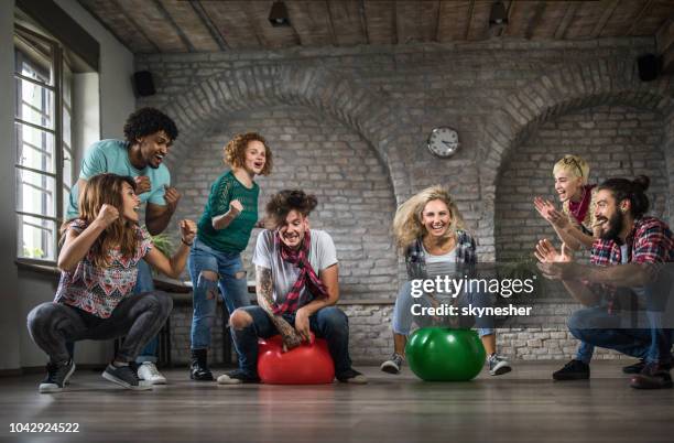 cheering during space hopper game at casual office! - hoppity horse stock pictures, royalty-free photos & images