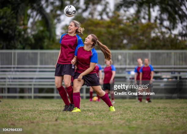 two female soccer players compete for the ball in front their team mates - football australien stock pictures, royalty-free photos & images