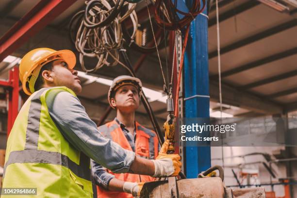 young businessman holding and working with remote control for operating crane - crane construction machinery stock pictures, royalty-free photos & images