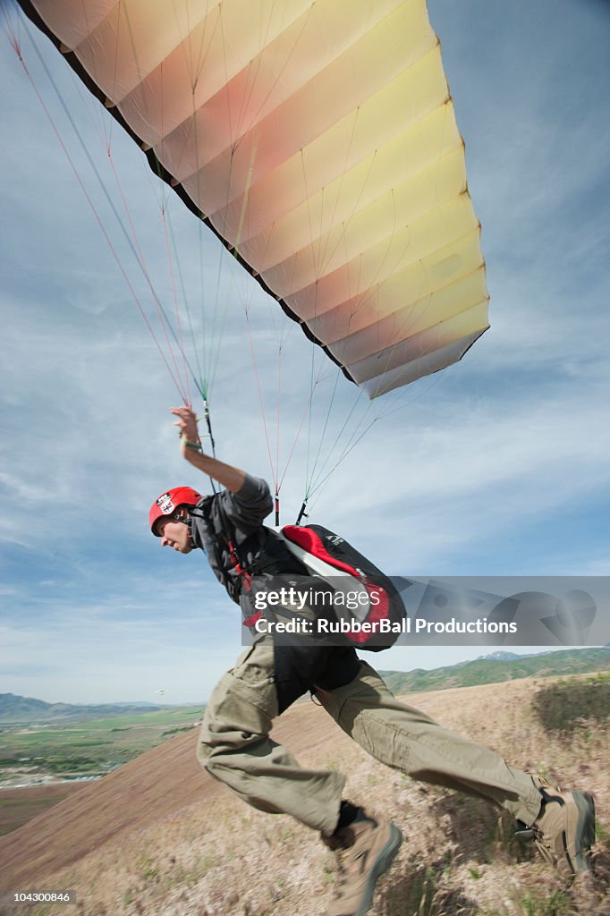 USA, Utah, Lehi, young paraglider starting from hill