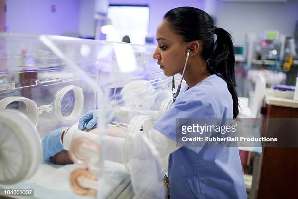 usa, utah, payson, nurse listening to heartbeat of newborn in incubator - neonatal intensive care unit stock pictures, royalty-free photos & images