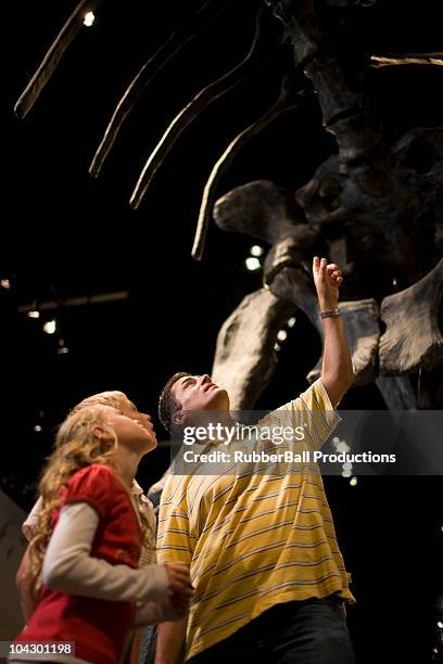 usa, utah, lehi, father looking at dinosaur with children (8-11) in museum - children museum stock pictures, royalty-free photos & images