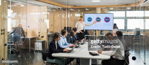 female financial analyst giving presentation to board members - business strategy stock pictures, royalty-free photos & images