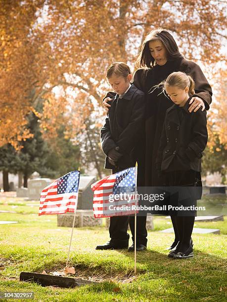 mother and two children at a funeral - military widow stock pictures, royalty-free photos & images