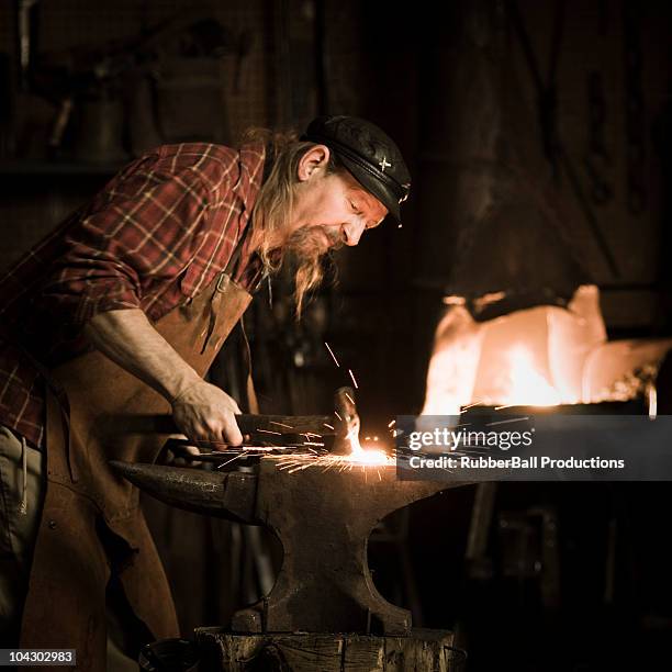 blacksmith holding a hammer - blacksmith sparks stock pictures, royalty-free photos & images