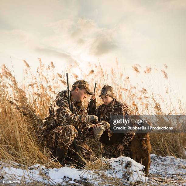 father and son duck hunting with their dog - ave aquática imagens e fotografias de stock