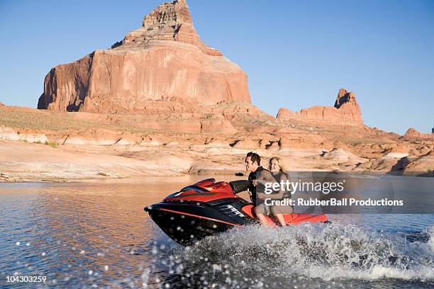 young couple on a wave runner - lake powell - fotografias e filmes do acervo