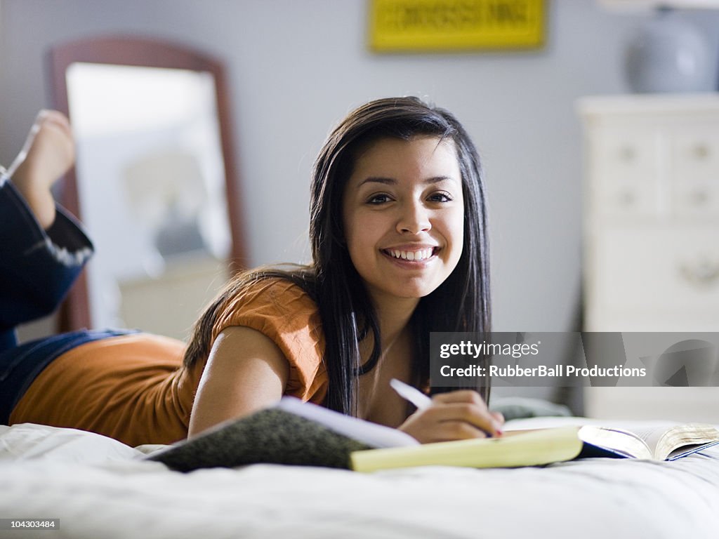 Chica estudiando en su cama
