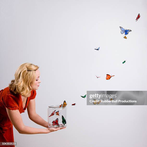 woman holding a jar of butterflies - butterfly on white stockfoto's en -beelden