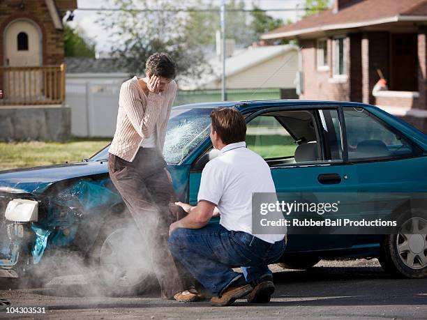 man helping a woman after a car accident - injured street stockfoto's en -beelden
