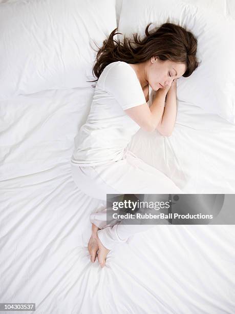 woman in bed - woman curled up stock pictures, royalty-free photos & images