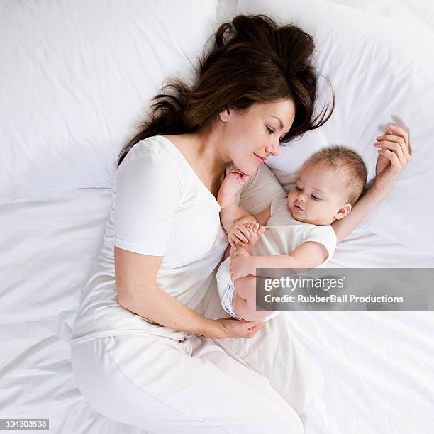 mother and baby in bed - bed on white stock pictures, royalty-free photos & images