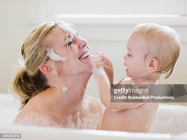 mother and baby taking a bubble bath - woman bath bubbles stock pictures, royalty-free photos & images